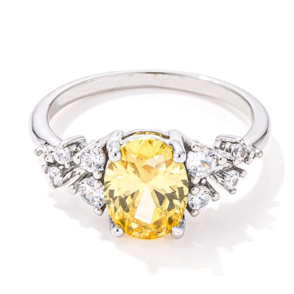 Ring with an oval yellow cubic zirconia center stone set in rhodium-plated metal