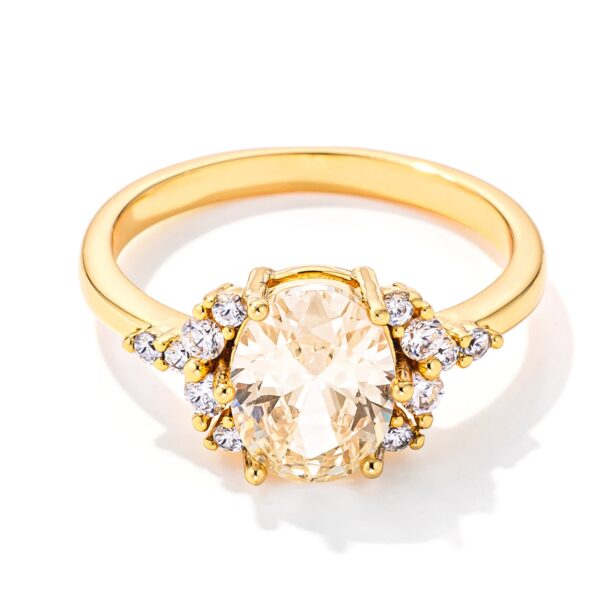 Goldtone ring with an oval canary yellow CZ center stone and smaller accent stones on the band