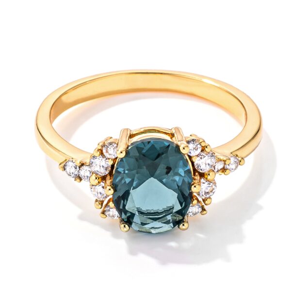 Goldtone ring with an oval blue and green cubic zirconia stone