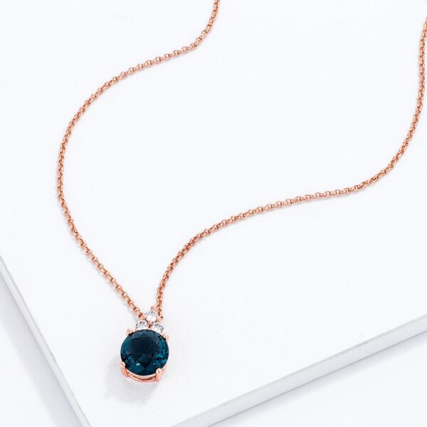 Close-up angle of the rose gold plated pendant showing the blue green cubic zirconia stone setting