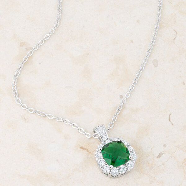 Pendant necklace displayed at an angle showing rhodium plating reflecting light across the metal surface