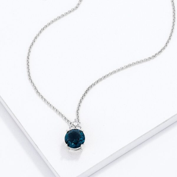 Close angle of the blue green cubic zirconia pendant showing stone sizes and silvertone plating