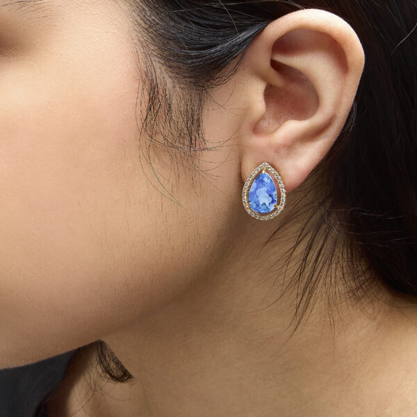 Earrings worn on a model's ear showing placement and profile