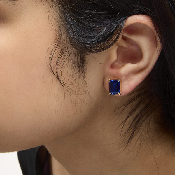 Model wearing the 18K yellow gold step-cut sapphire stud earrings