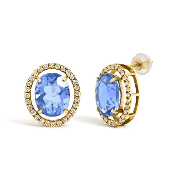 Side angle of a gold stud earring showing the prong setting holding the blue fluorite stone