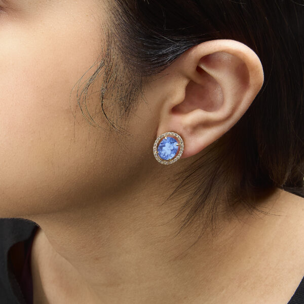Blue fluorite and diamond stud earrings worn on an ear