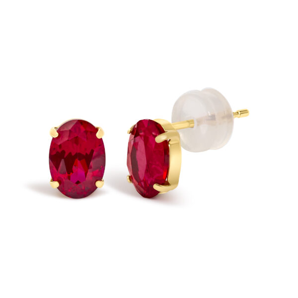 Side angle of an 18K yellow gold ruby stud earring showing the prong setting and post