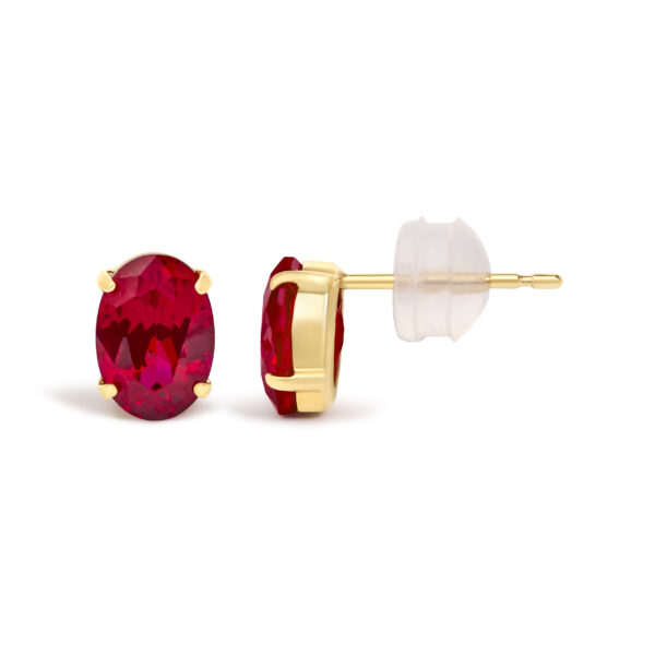 Close-up of an oval ruby stud earring highlighting the stone's red color and clarity