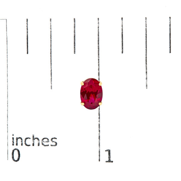 18K yellow gold ruby stud earrings shown next to a scale reference for size