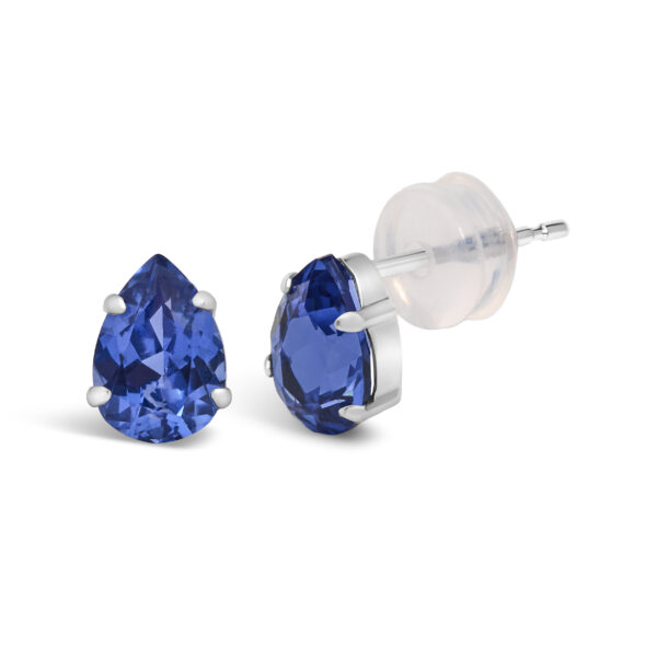 Close angled view of a platinum stud earring showing the prong setting around the blue sapphire