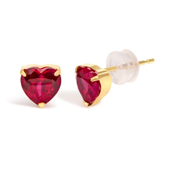 Side angle of an 18K yellow gold ruby heart stud earring showing the prong setting and post