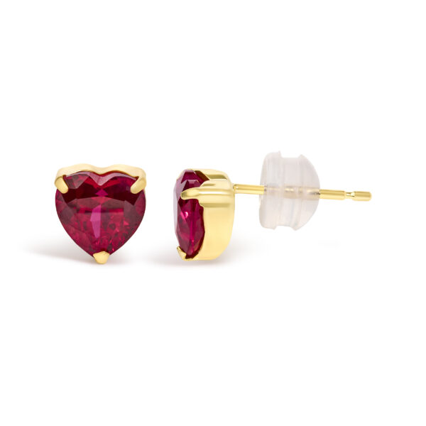 Close-up of a heart-cut red ruby stud earring highlighting facets and prong setting