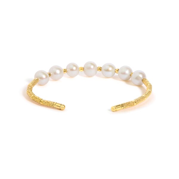 Side angle of the gold pearl cuff bracelet showing the open ends of the band
