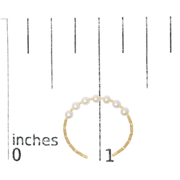 Gold pearl cuff bracelet photographed next to a ruler for scale reference