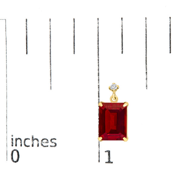 Earrings shown next to a scale reference indicating their size