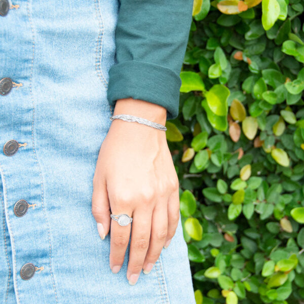Side angle of the crossed band ring showing the woven metal texture