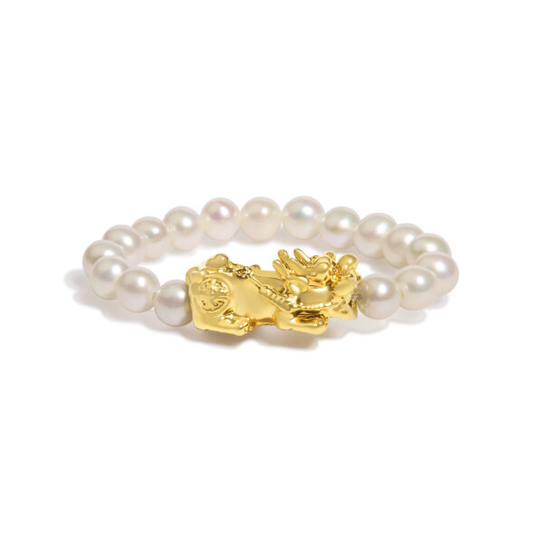 Gold dragon charm shown from above, highlighting its sculpted form on the ring