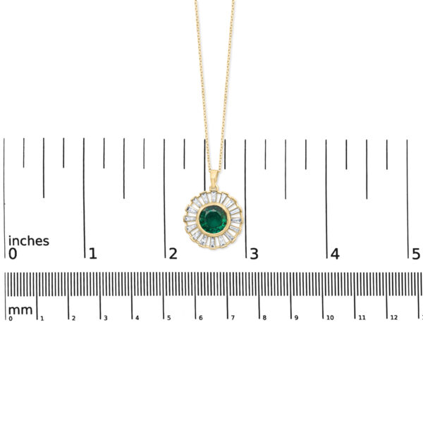 Pendant photographed next to a ruler for scale reference