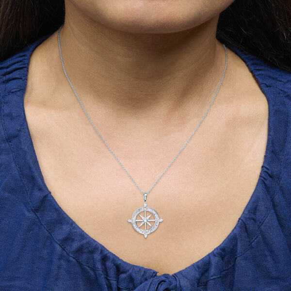Compass medallion pendant necklace worn at the collarbone on a model