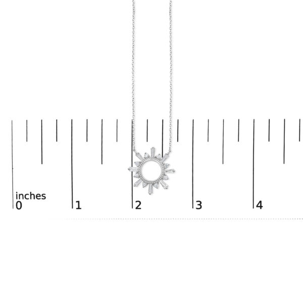 Starburst pendant photographed next to a ruler for scale reference