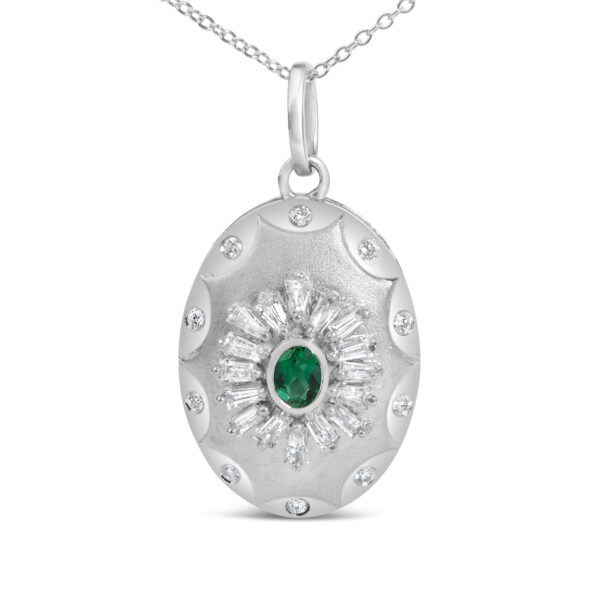 Close-up of the medallion showing the oval emerald and baguette diamonds set around it