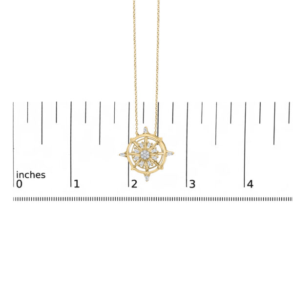 Compass pendant shown next to a ruler for scale reference