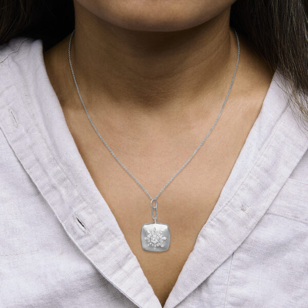 Sunburst pendant necklace worn at the neckline showing chain length