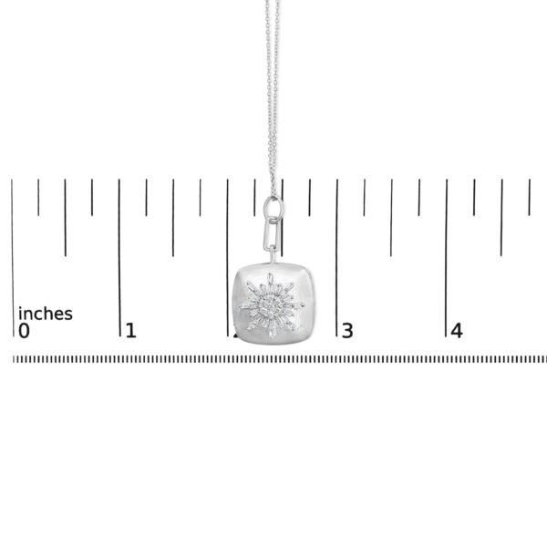 Sunburst pendant necklace shown next to a ruler for scale reference