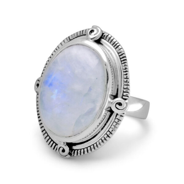 Oxidized oval ring with a large cabochon stone in an ornate scrolled bezel setting