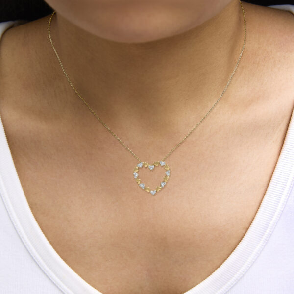 Puffed heart pendant necklace worn on a model, resting on the chest