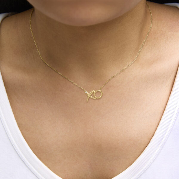 24K gold vermeil XO pendant necklace displayed on a model
