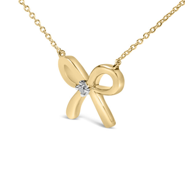 Close view of the bow tie pendant showing the prong-set diamond accent at its center