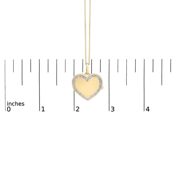 Heart locket pendant shown near a ruler for size reference