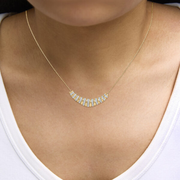 Pendant necklace worn on a model, showing the ribbed pendant on the cable chain
