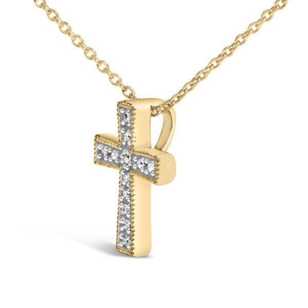 Close-up of the round diamonds set into the cross pendant in a prong setting