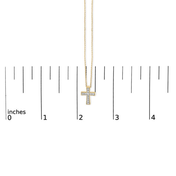 Cross pendant necklace shown at scale to indicate its size against a reference