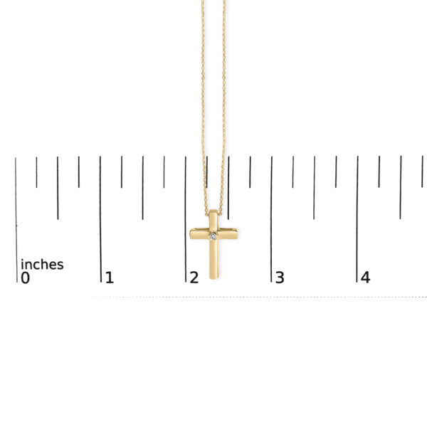 Cross pendant necklace shown with a scale reference to indicate its size