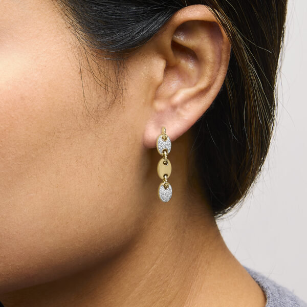 Disc link earrings worn on a model's ear, showing how the design hangs