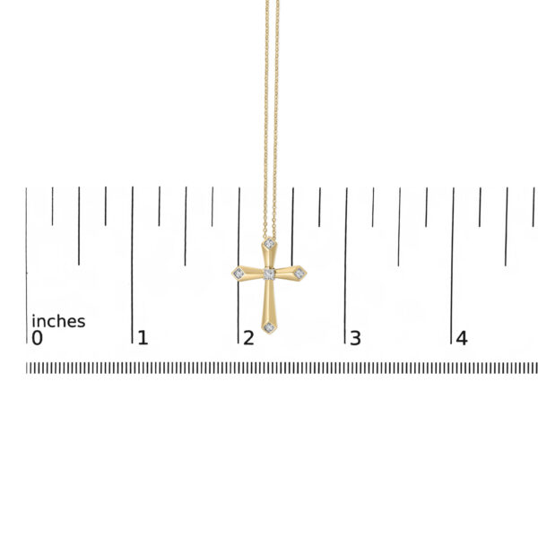 Cross pendant necklace shown next to a scale reference to indicate its actual size
